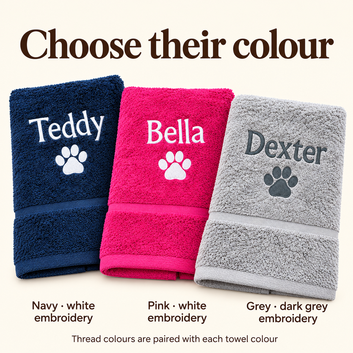 Navy and pink towels with white embroidery, and grey with dark grey embroidery
