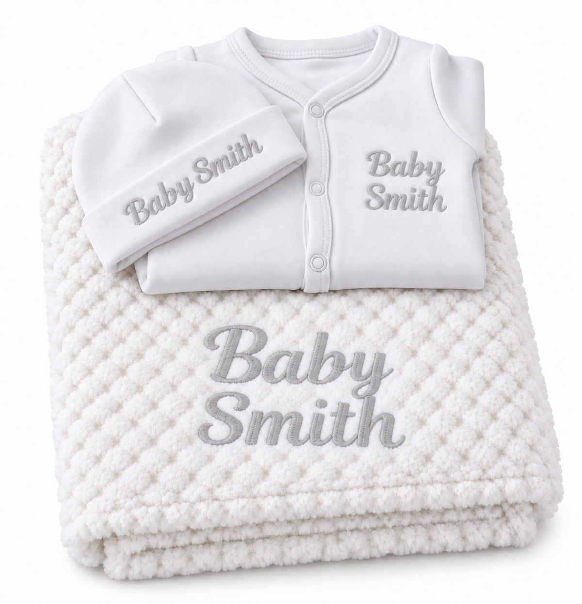 White set with grey embroidery showing personalised blanket, sleepsuit and hat on a white background.