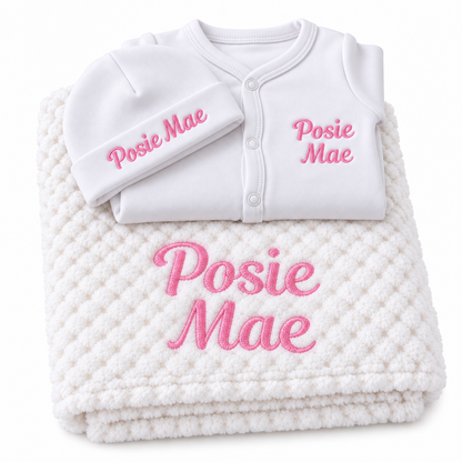White set with pink embroidery showing personalised blanket, sleepsuit and hat on a white background.