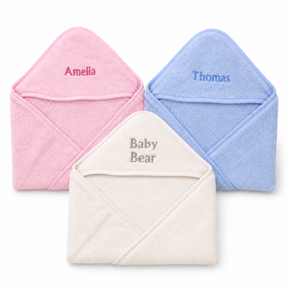 Pink, blue and white personalised hooded towels on a clean white background.